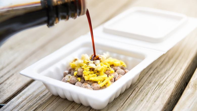 Mixing natto with soy sauce and mustard before serving over rice